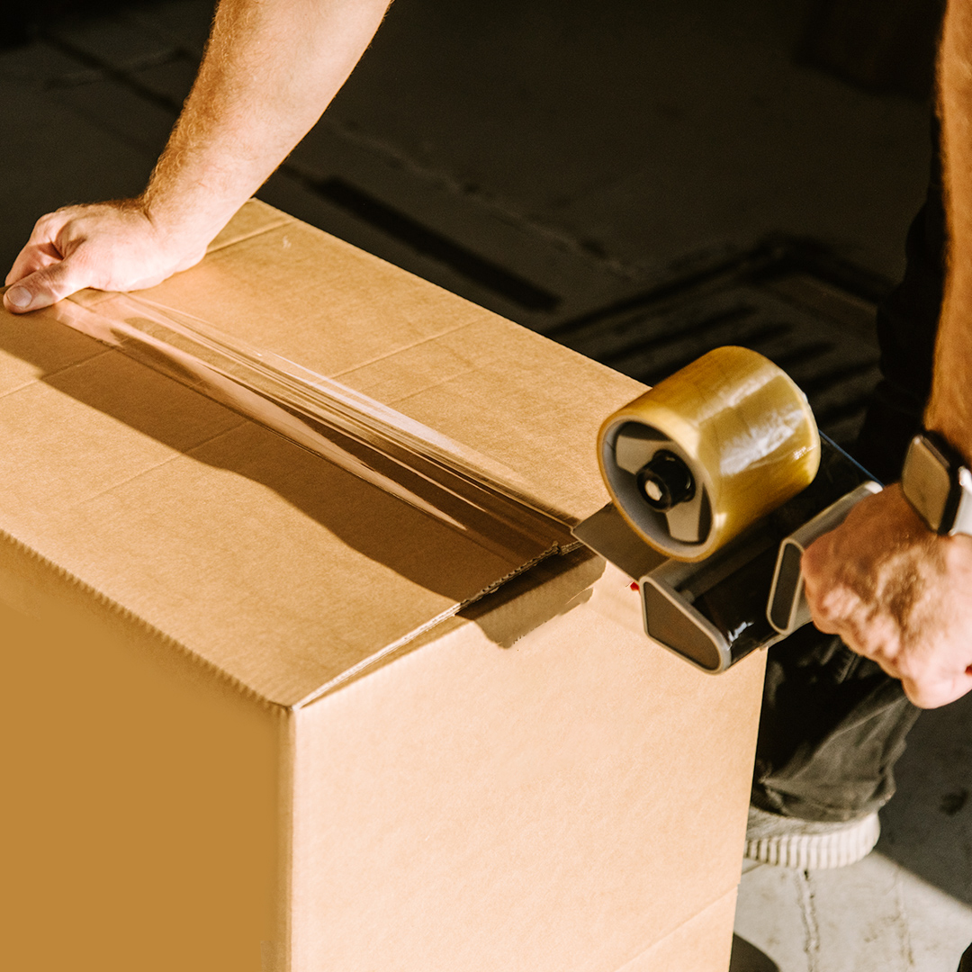 A picture of someone taping up a box